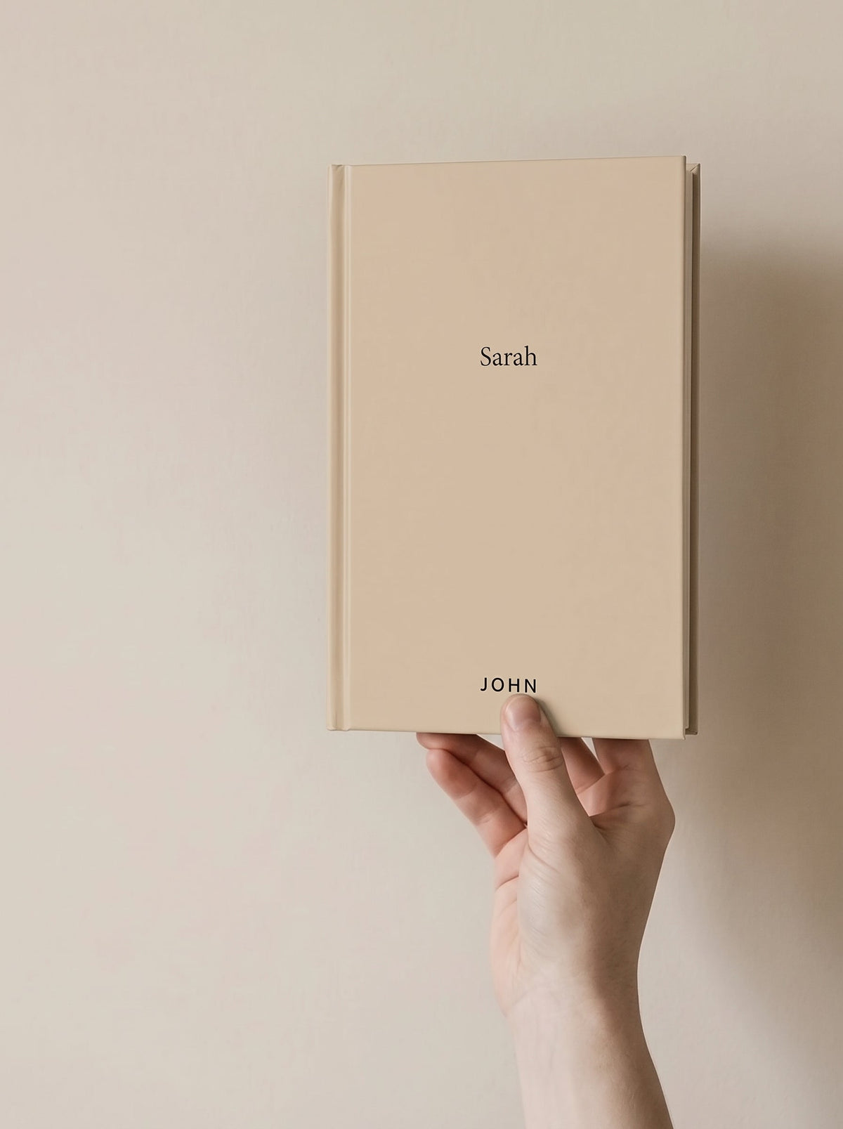 A hand holding the John hardcover, showing how big the book actually is