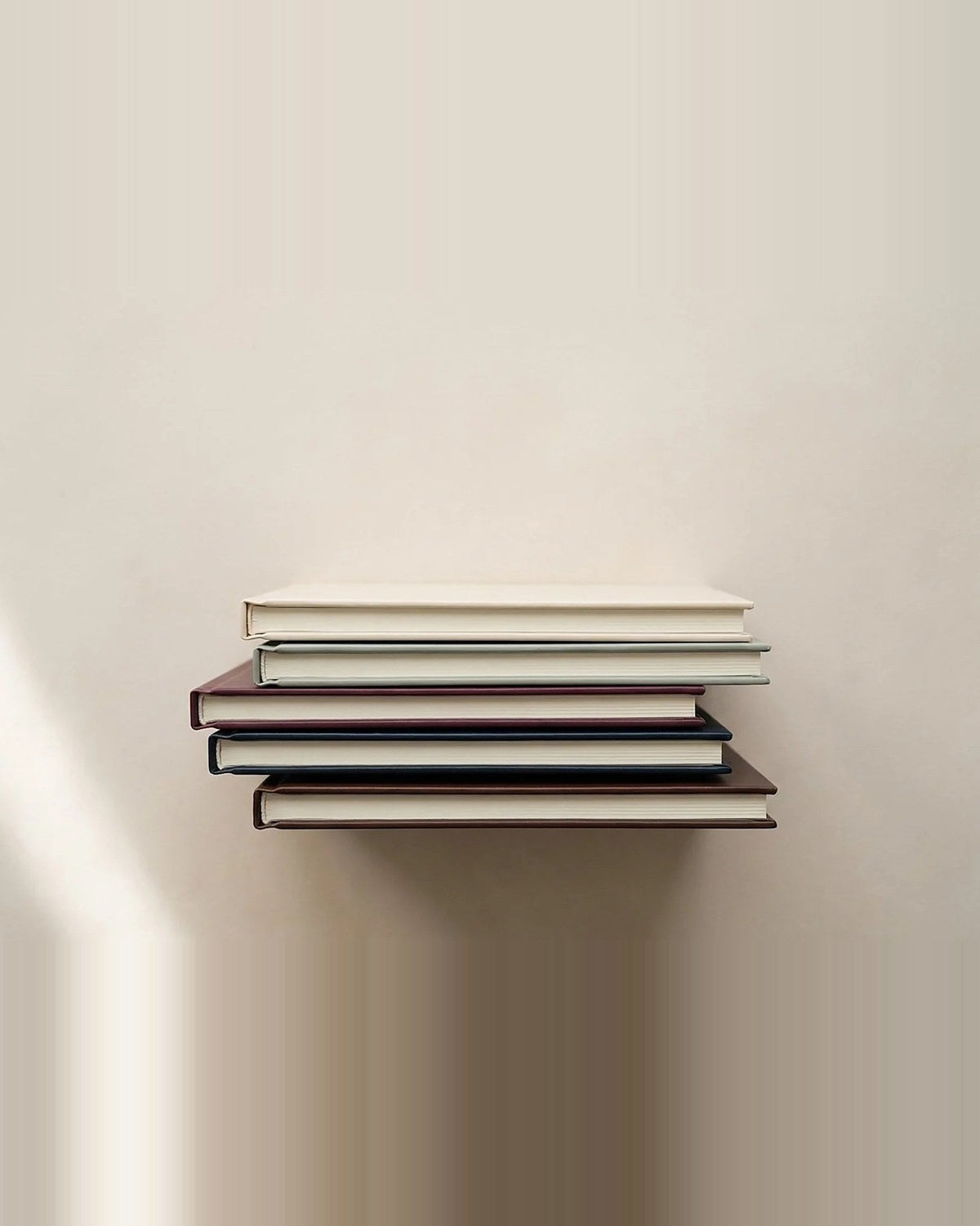 Five copies stacked, each in a different cover colour