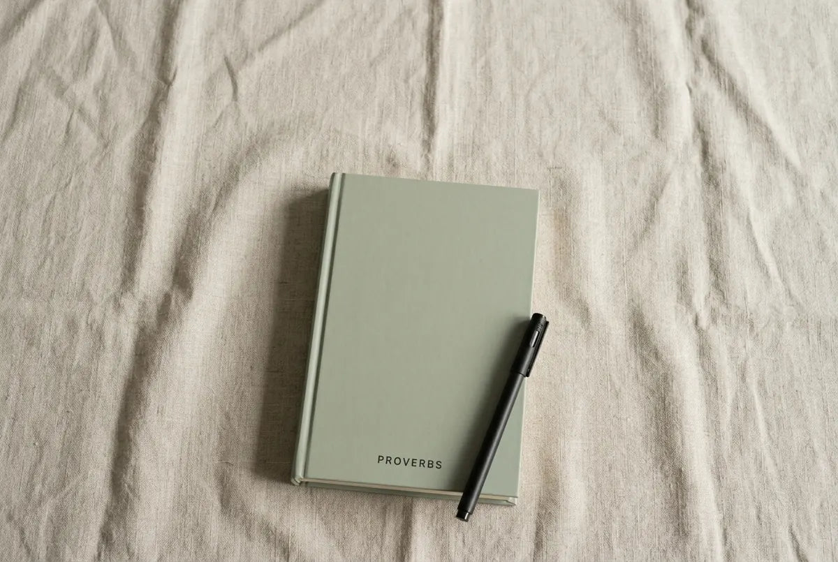 The closed book on linen with a pen resting across it