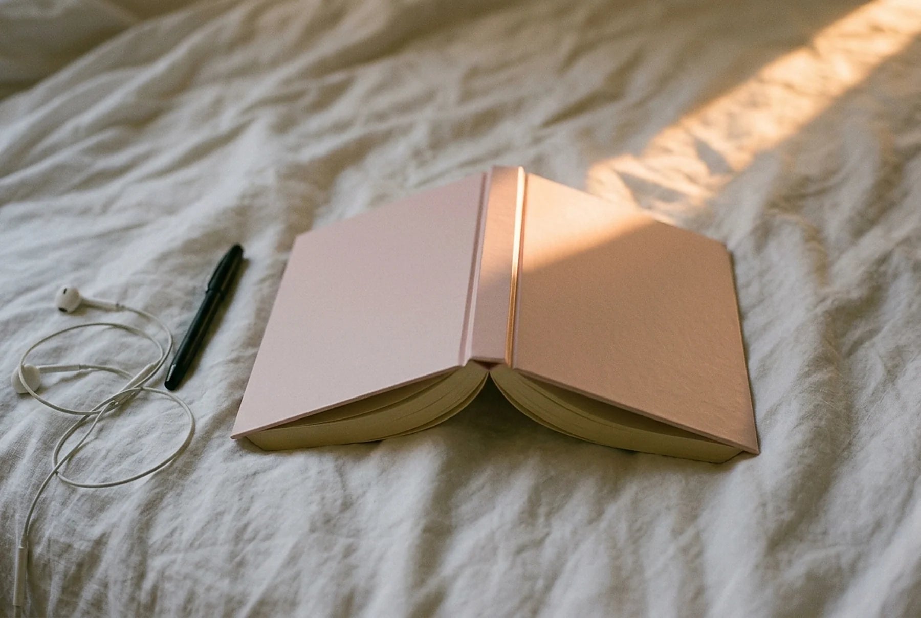 The book lying open face down on a bed in late afternoon light